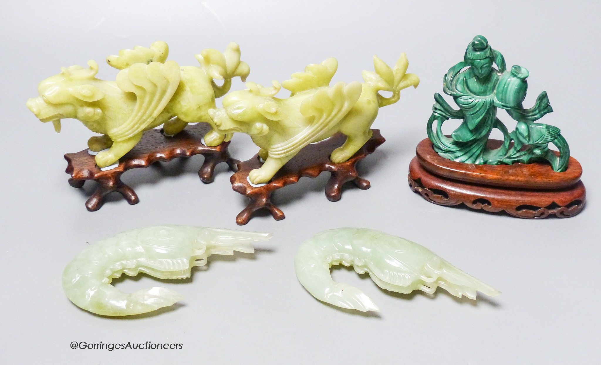 A group of Chinese hardstone carvings, mid 20th century to include a pair of mythical beasts, a pair of bowenite jade figures of tiger prawns and a malachite figure of a lady, three wood stands